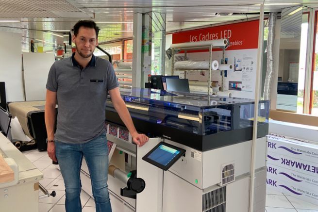 Adrien Corfu, large format production manager at Doc Factory, in front of the Canon Colorado 1630